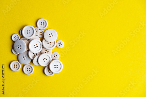 a lot of wooden buttons on a yellow background, free space. Accessories for sewing