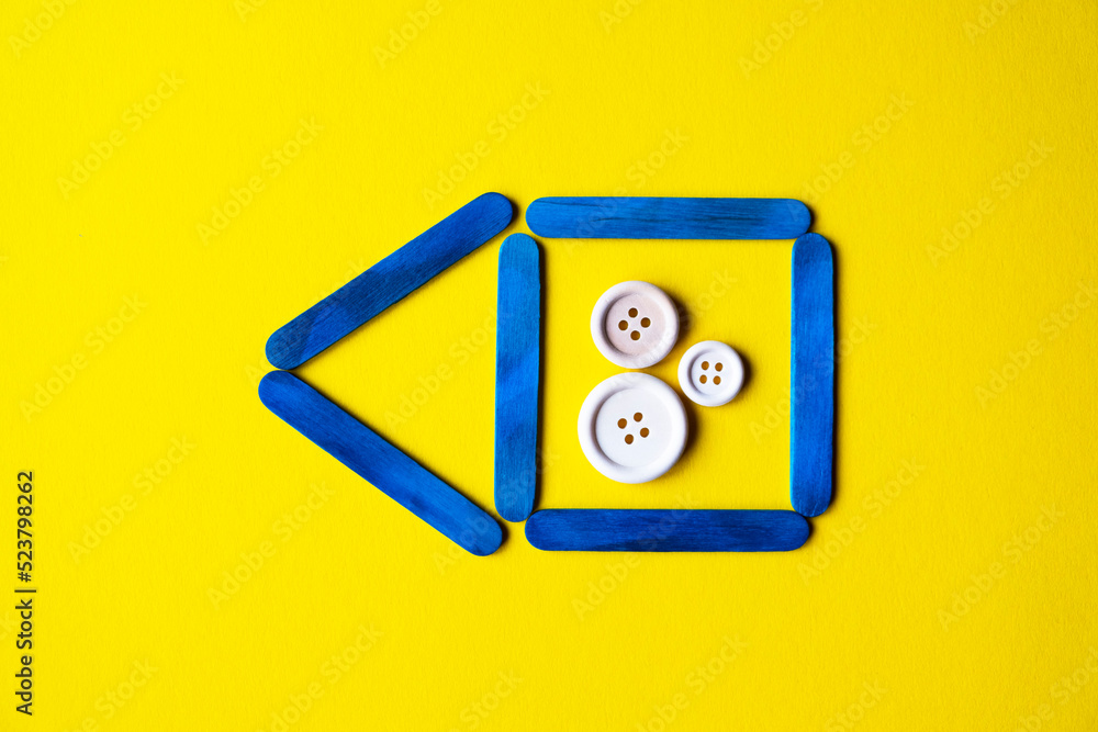 blue color house made of wooden sticks on a yellow background