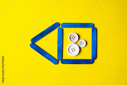 Obraz na płótnie blue color house made of wooden sticks on a yellow background w salonie