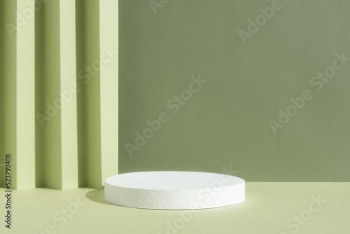 Abstract empty white podium on a green background. A scene with a geometric background. Backdrop for the product presentation.