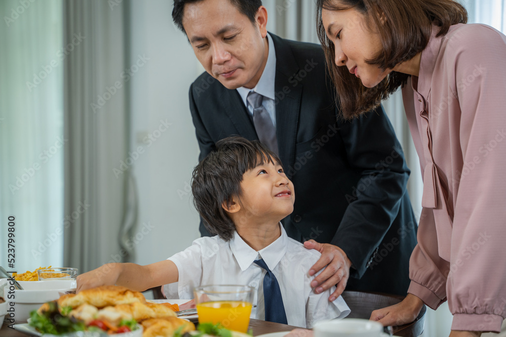 Happy parents feeding their son during breakfast time in the kitchen.. Happy parents feeding their son during breakfast time in the kitchen..