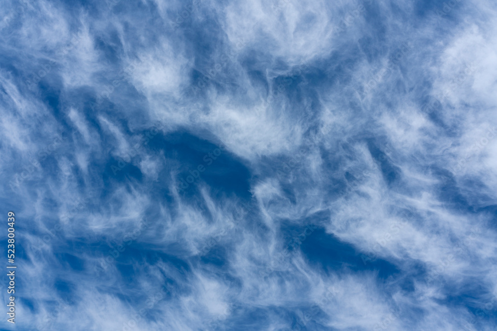 Cumulus white clouds on a blue sky for use as a cloudscape texture background, stock photo image