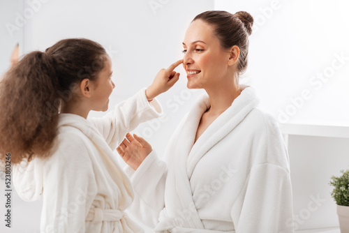 beauty, hygiene, morning and people concept - happy smiling mother and daughter having fun in at bathroom