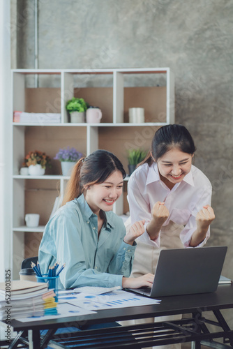 Two young Asian businesswoman discuss investment project working and planning strategy. Business people talking together with laptop computer at office.