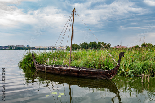 Ancient medieval wooden ship. Wooden old ship in vintage style set in misty lake