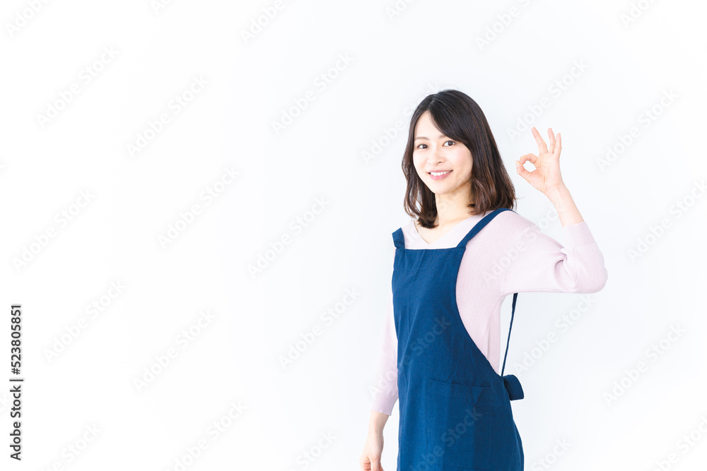エプロンを着てOKサインを示す若い女性 エプロンを着てOKサインを示す若い女性