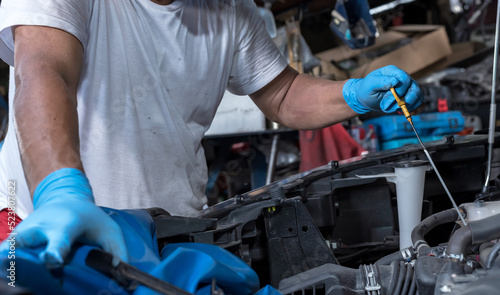 Close up car mechanic checking oil level in car auto repair service, Car maintenance concept