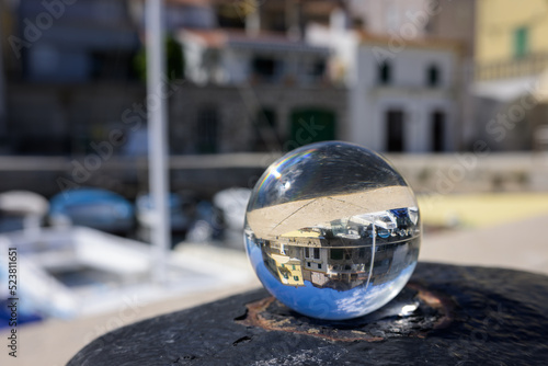 Glass sphere lying on a rusty bollard