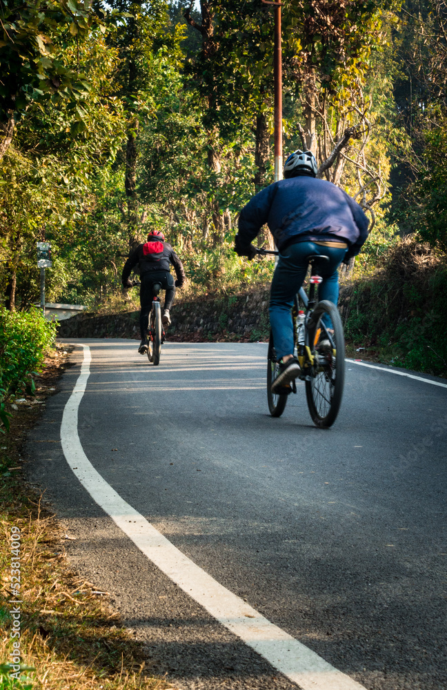 February 13th 2022. Dehradun, Uttarakhand, India. A group of cyclist with backpack riding on the empty streets of dehradun city of India in the morning.