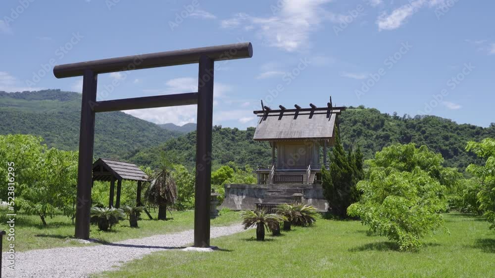 ancient shinto shrine with torii entrance among green meadows against mountains and blue sky at background on a breezy clear day in summer, Luye Taitung, Taiwan ancient shinto shrine with torii entrance among green meadows against mountains and blue sky at background on a breezy clear day in summer, Luye Taitung, Taiwan