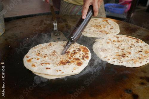  cooking roti chapati on a big cooking pan  photo