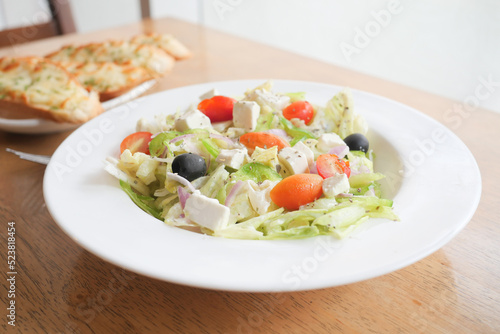 Close up of greek salad in a bowl on table.