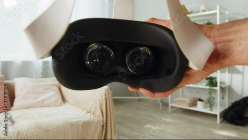 Wearing virtual reality glasses POV, playing video games, gamer using new generation gaming headset for entertainment at home, future technology concept.