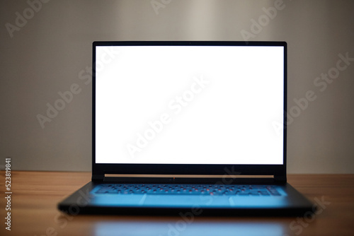 Laptop or notebook with blank screen on wood table. Clipping path.