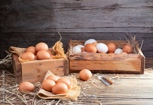 Chicken eggs are laid on the ground and put in a basket on a wooden table on, a rural farm