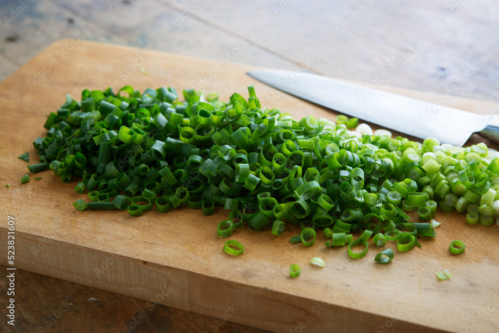 Chopped scallions or leeks on cutting board.