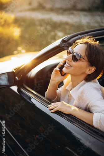 Woman road tripping by her car cabriolet