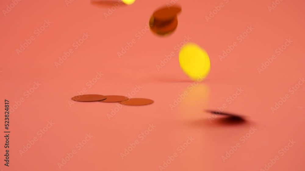 Falling confetti on a peach-pink background. Slow motion. Falling confetti on a peach-pink background. Slow motion.