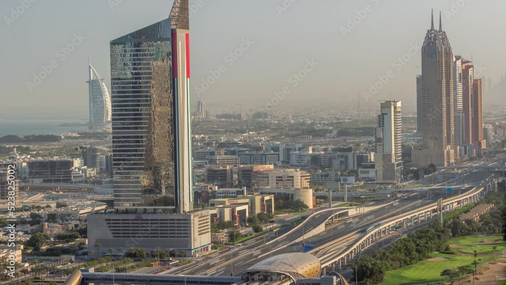 Aerial view of Sheikh Zayed Road in Dubai Internet City area timelapse. Skyscrapers and traffic on a highway with metro station early morning during sunrise Aerial view of Sheikh Zayed Road in Dubai Internet City area timelapse. Skyscrapers and traffic on a highway with metro station early morning during sunrise