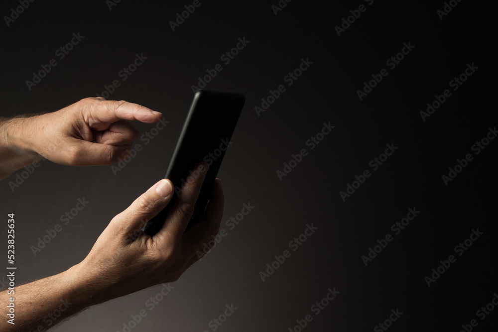 Hand holding smart phone with finger touching display, side view Hand holding smart phone with finger touching display, side view