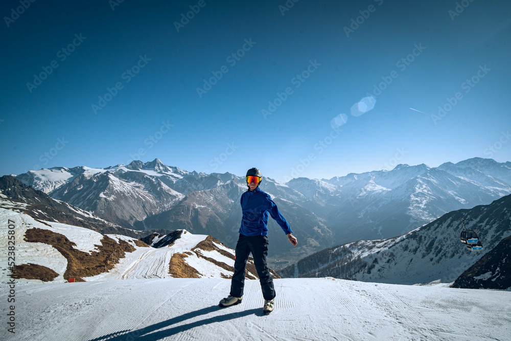 skier on the top of mountain in a snowy mountain landscape and blue sky