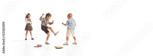 Portrait of little children  boys and girl  pupil in school uniform playing together on lessons break isolated over white background