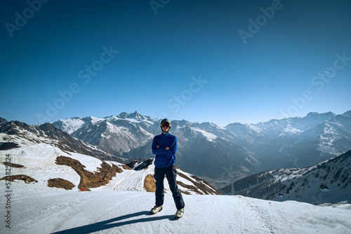 skier on the top of mountain in a snowy mountain landscape and blue sky