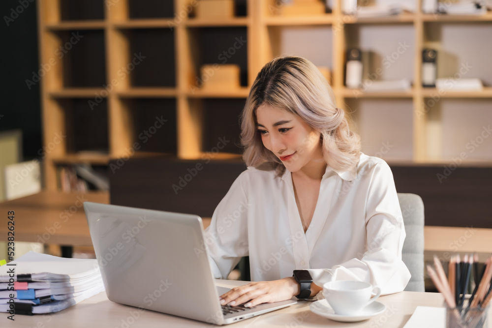 Beautiful Asian portrait businesswoman manager smile workingin office with a laptop in the modern office sitting online marketing financial communication. Beautiful Asian portrait businesswoman manager smile workingin office with a laptop in the modern office sitting online marketing financial communication.