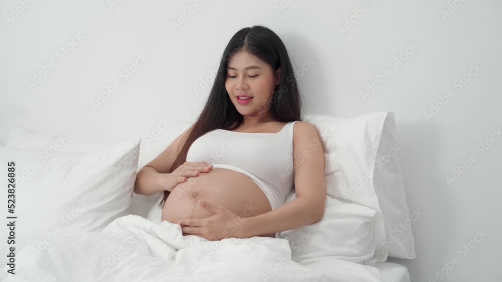 Asian happy pregnant woman is sitting on bed and touching her belly. pregnancy, motherhood, people and expectation concept
Asian happy pregnant woman is sitting on bed and touching her belly. pregnancy, motherhood, people and expectation concept