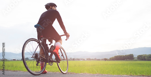 Rear view of a cyclist on the road in the evening. Fitness concept.