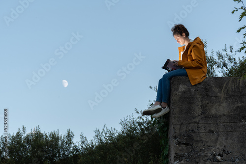chica leyendo un libro en la naturaleza photo
