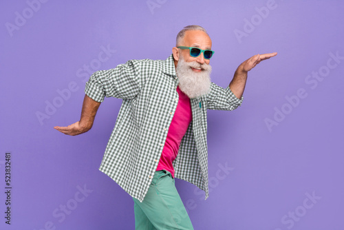 Profile portrait of overjoyed carefree person enjoy free time dancing hands make moves isolated on purple color background