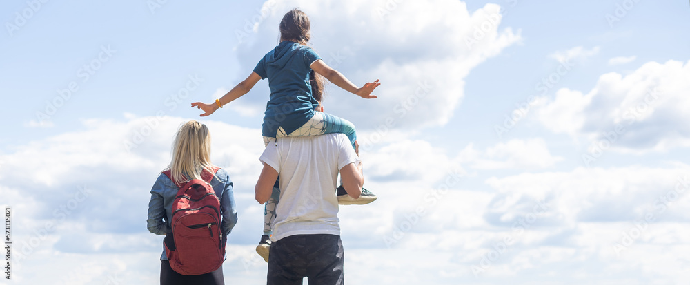 Mother, father hugging son, and daughter in summer mountains. Happy family smiling and standing on the green grass in the field at sunset. Kids with parents. Family weekend Mother, father hugging son, and daughter in summer mountains. Happy family smiling and standing on the green grass in the field at sunset. Kids with parents. Family weekend