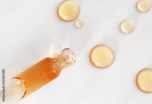 Pipette with fluid serum, oil, face gel cleaner. Cosmetics and healthcare concept closeup. Dose of retinol with air bubbles. Flat lay. Monkeypox, coronavirus research photo