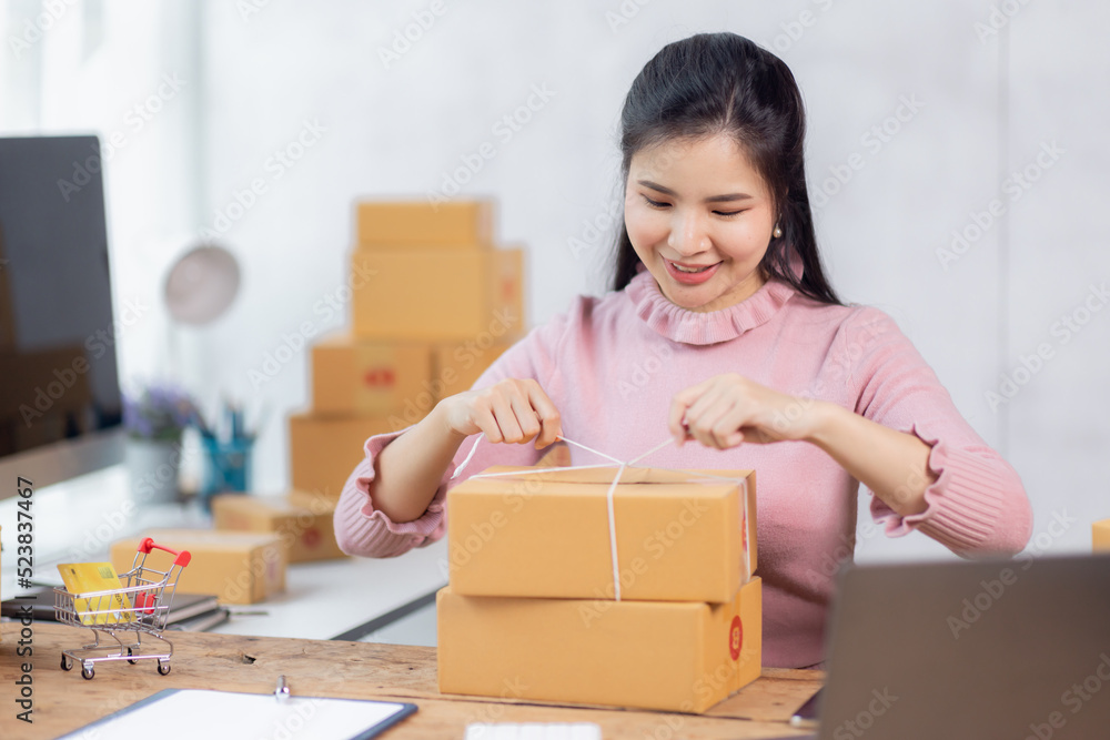 Portrait of young Asian woman working SME with a box at home the workplace.start-up small business owner, small business entrepreneur SME or freelance business online and delivery concept.