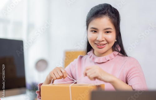 Portrait of young Asian woman working SME with a box at home the workplace.start-up small business owner, small business entrepreneur SME or freelance business online and delivery concept.