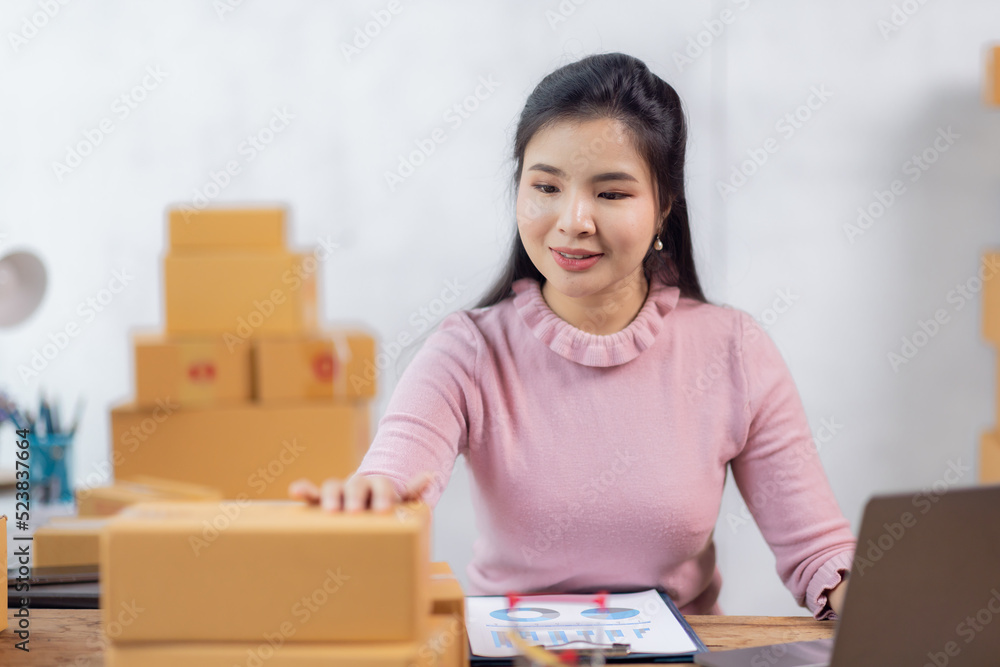 Portrait of young Asian woman working SME with a box at home the workplace.start-up small business owner, small business entrepreneur SME or freelance business online and delivery concept. Portrait of young Asian woman working SME with a box at home the workplace.start-up small business owner, small business entrepreneur SME or freelance business online and delivery concept.