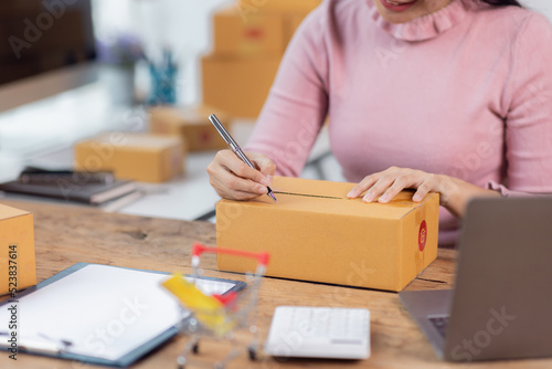 Portrait of young Asian woman working SME with a box at home the workplace.start-up small business owner, small business entrepreneur SME or freelance business online and delivery concept.