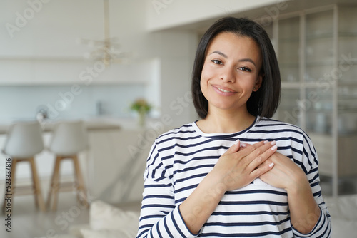 Free Download Hispanic trendy girl in sailor shirt keeps hands close to heart. Happy woman showing love. - GFXLoad