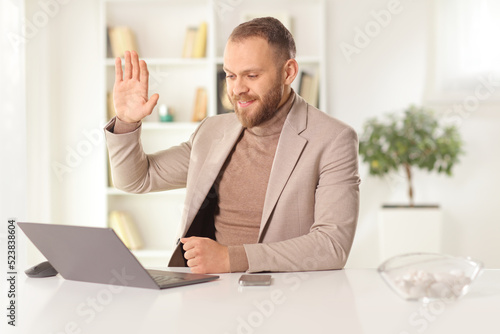 Man sitting in front of a laptop computer and making a video call