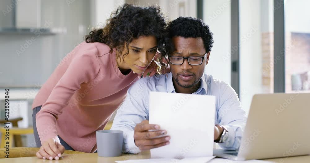 Home finance, budget planning and money management with a young couple reading paper work, talking and discussing their savings and investment for the future. Man and woman doing finances on a laptop Home finance, budget planning and money management with a young couple reading paper work, talking and discussing their savings and investment for the future. Man and woman doing finances on a laptop