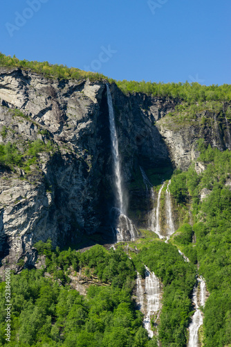 Geiranger Fjord in Norway with waterfalls cascading down the high mountains.