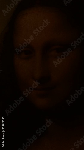 Face of Gioconda o Mona Lisa illuminated, fade in and out. Vertical. 4K photo