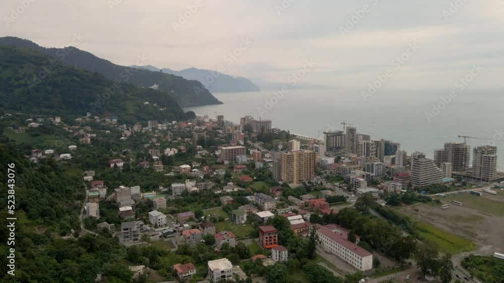Drone flying over the city of Gonio on a rainy day. Fog shrouds the mountains, lush greenery grows on the slopes. Drone flying over the city of Gonio on a rainy day. Fog shrouds the mountains, lush greenery grows on the slopes.