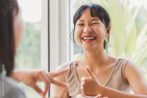 Young attractive Asian women using sign hand finger language conversation with deaf person. Cheerful happy using nonverbal communication to persons with disabilities.