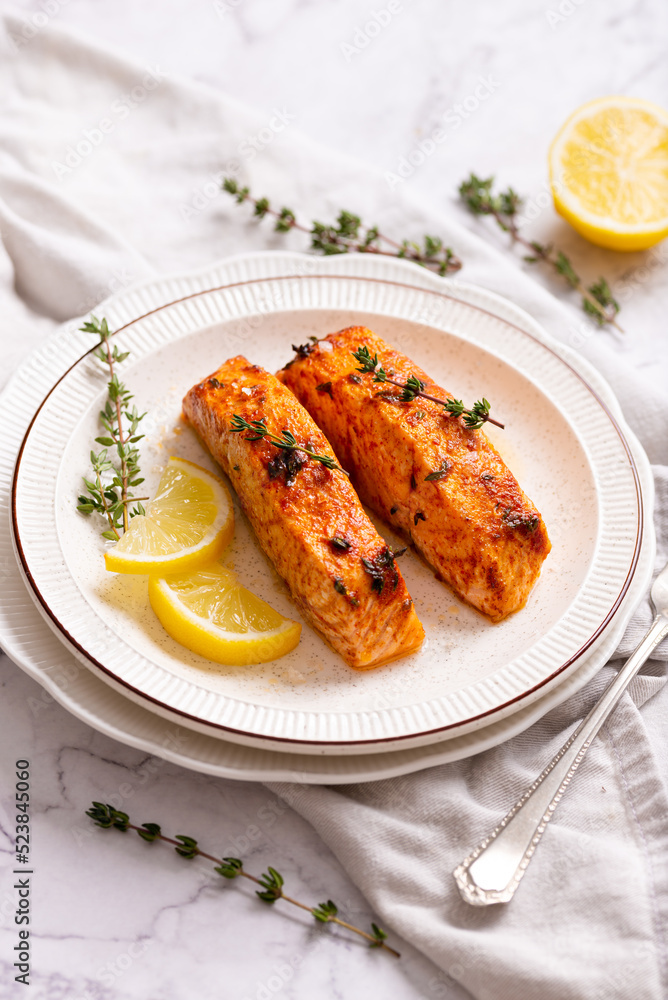 plate of grilled salmon with lemon wedges plate of grilled salmon with lemon wedges