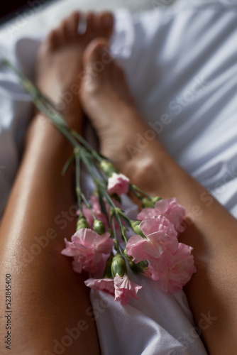 Foot care. Women's legs and flowers