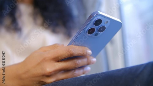 Wallpaper Mural Woman using modern mobile phone with triple camera. Black female person browsing social media app on new smartphone in blue color Torontodigital.ca