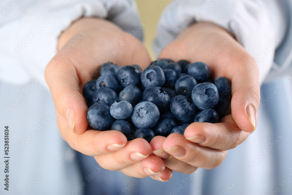 Woman holding tasty fresh blueberries, closeup view Woman holding tasty fresh blueberries, closeup view