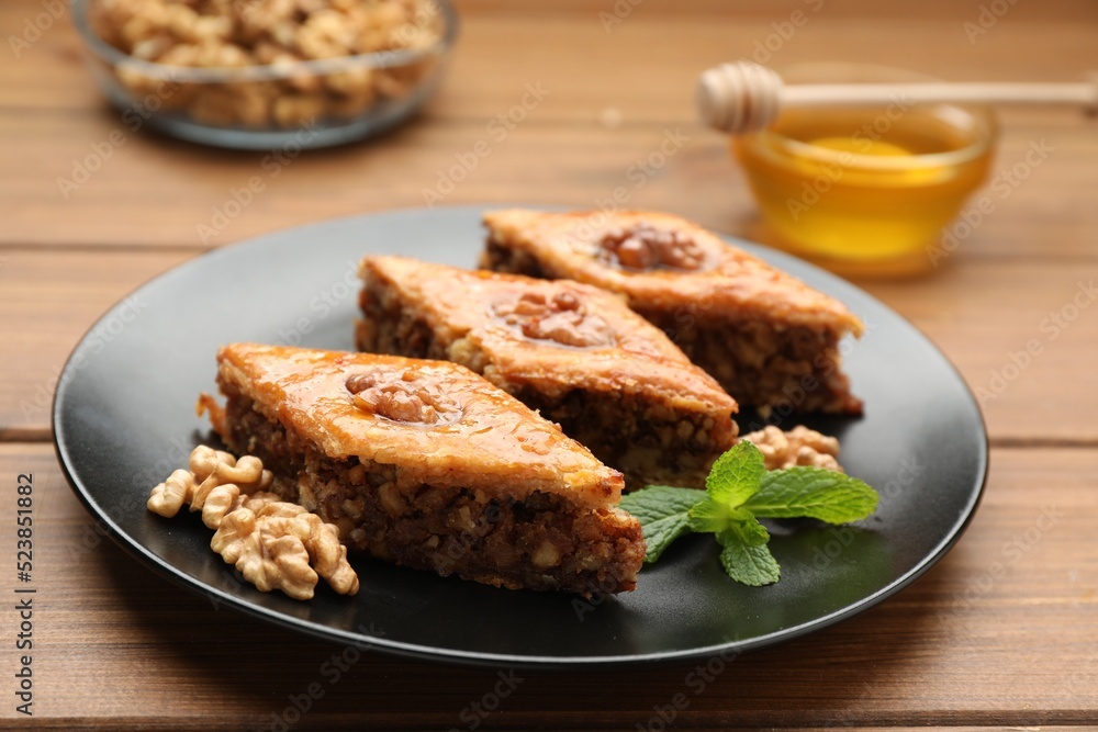 Delicious honey baklava with walnuts on wooden table, closeup Delicious honey baklava with walnuts on wooden table, closeup